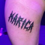 Tatuering i hardcorestil, text över lår Marica, av tatuerare Flor