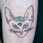 Tatuering i bara solida linjer av en katt med tre ögon, av tatuerare Flor.