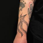 Blixtlåsliknande mönster över underarm, tatuering av tatuerare Flor