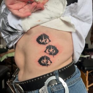 Ögon med blänk i tatuerade över revben i blackwork stil, av taterare Brutalist Baby.