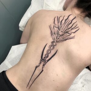 Tattoo over back in blackwork style. A dekorative torch, by queer tattooer Bahi.