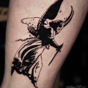 Death angel with horns and knife, tattooed in blackwork style over leg.